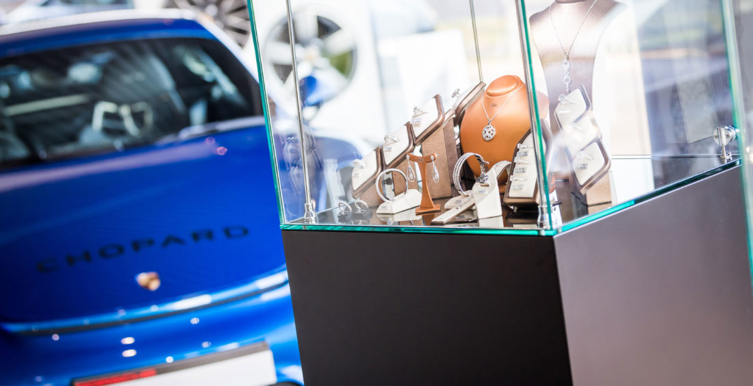 Blue Porsche behind a glass cabinet of Jewellery